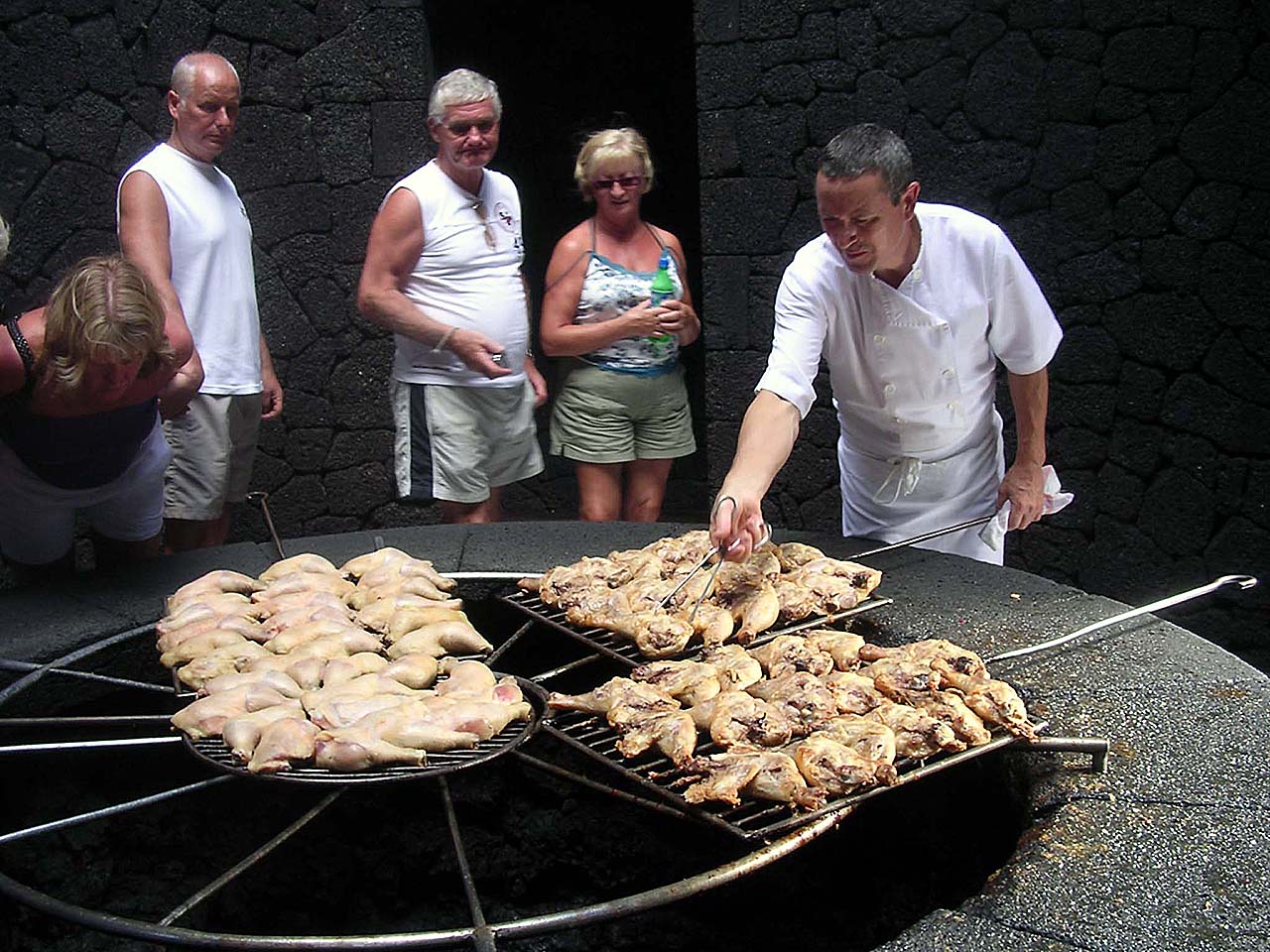 O cozinheiro prepara o frango na grelha sobre a brasa vulcânica - Foto: unfinishedman.com