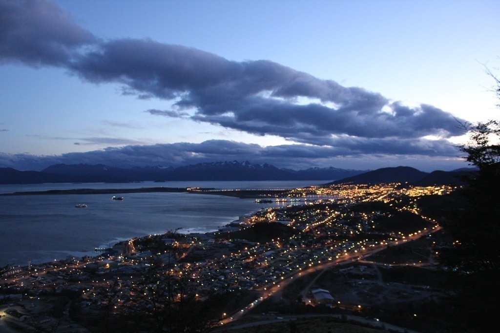 Cidade de Ushuaia vista de cima do hotel Arakur, ao anoitecer, quando as luzes das casas começam a se acender. 