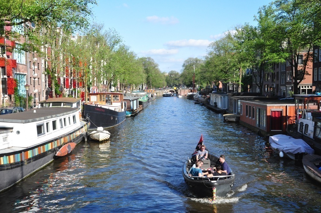 Grupo de amigos andam de barco em um dos canais de Amsterdam