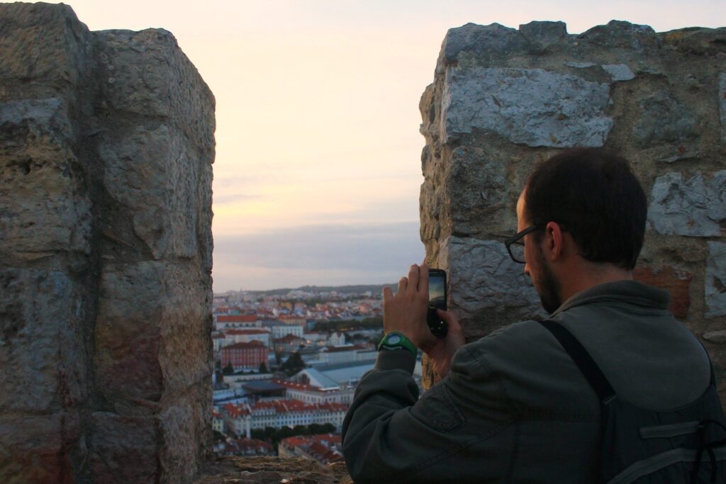 Homem tirando foto da vista de Lisboa do alto do castelo de São Jorge