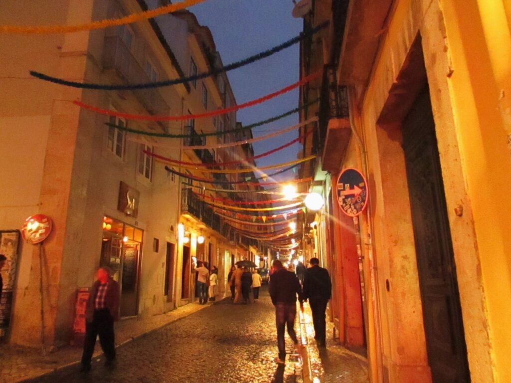 pequena rua com pendentes coloridos ligando os prédios de cada lado. 