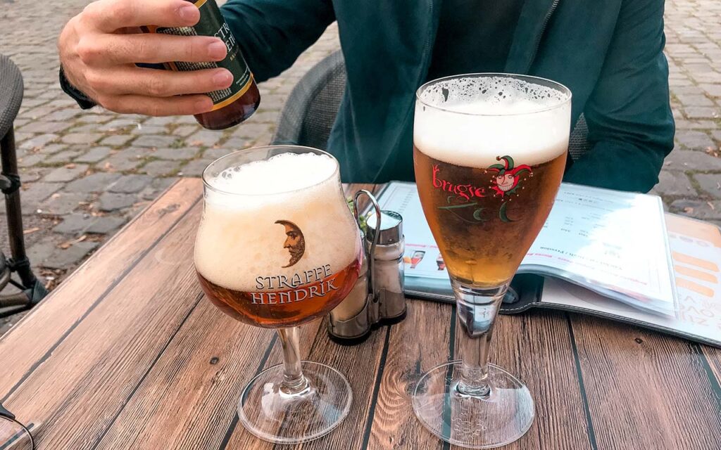 Foto de dois copos em cima da mesa, com cervejas belgas. 