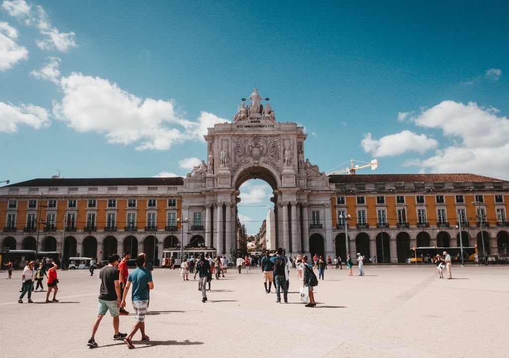 Praça do Comercio, em Lisboa, durante a tarde diversos turistas passeando em frente ao arco da rua augusta